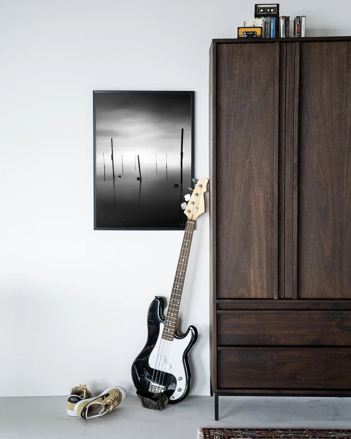 Kunsttrykk på syrefritt papir, lerret og glass. Svart-hvit foto av påler eller stokker som stikker opp fra en sjø. 