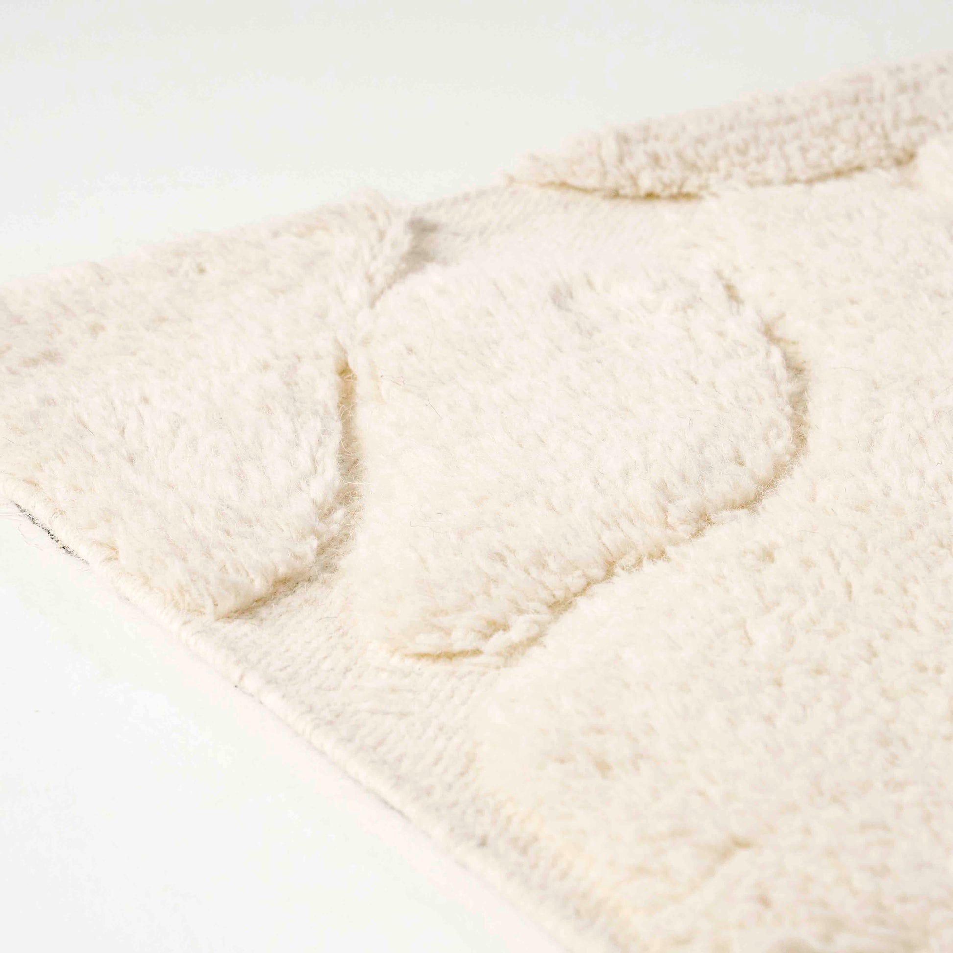 Kremhvit gulvteppe i ull.