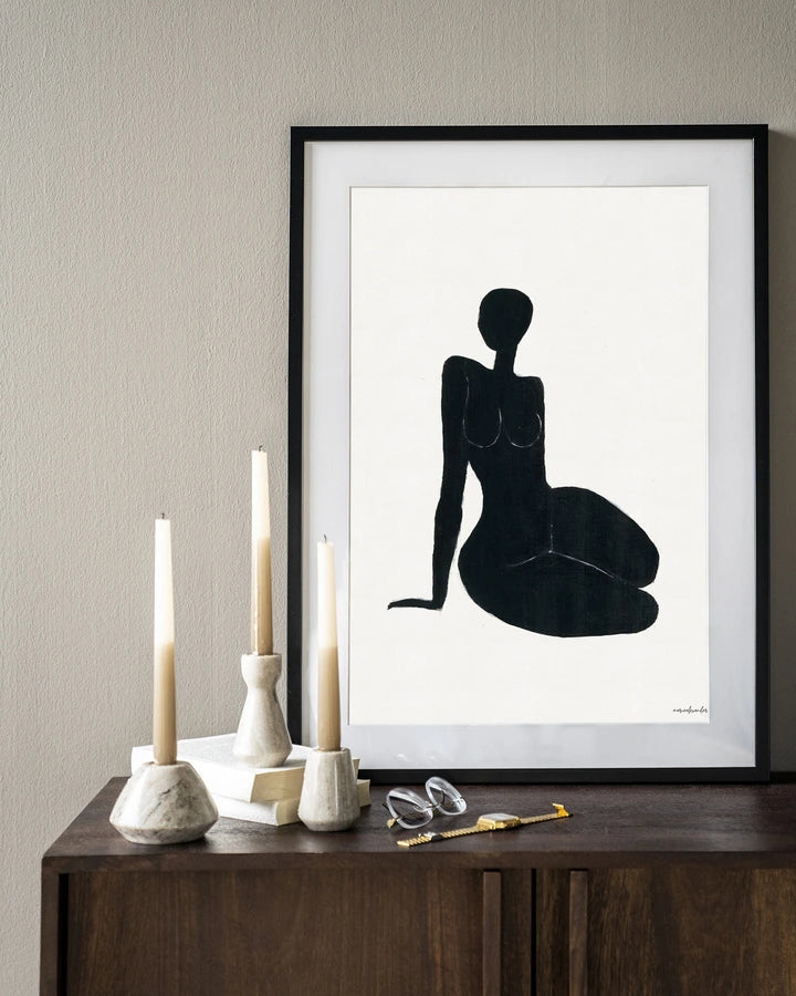 Kunsttrykk på syrefritt papir, lerret og glass. Svart kvinnelig siluett som sitter på gulvet. Fargepalett: svart mot hvit