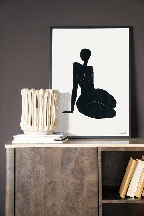 Kunsttrykk på syrefritt papir, lerret og glass. Svart kvinnelig siluett som sitter på gulvet. Fargepalett: svart mot hvit