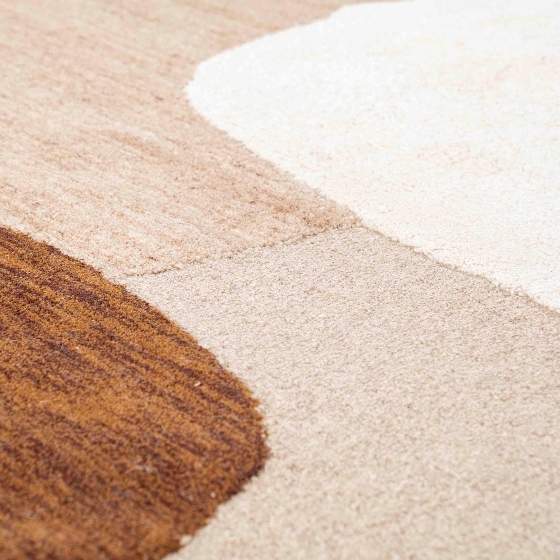 Gulvteppe i organiske former. Beige grrunnfarge med brune og hvite fargeflater.