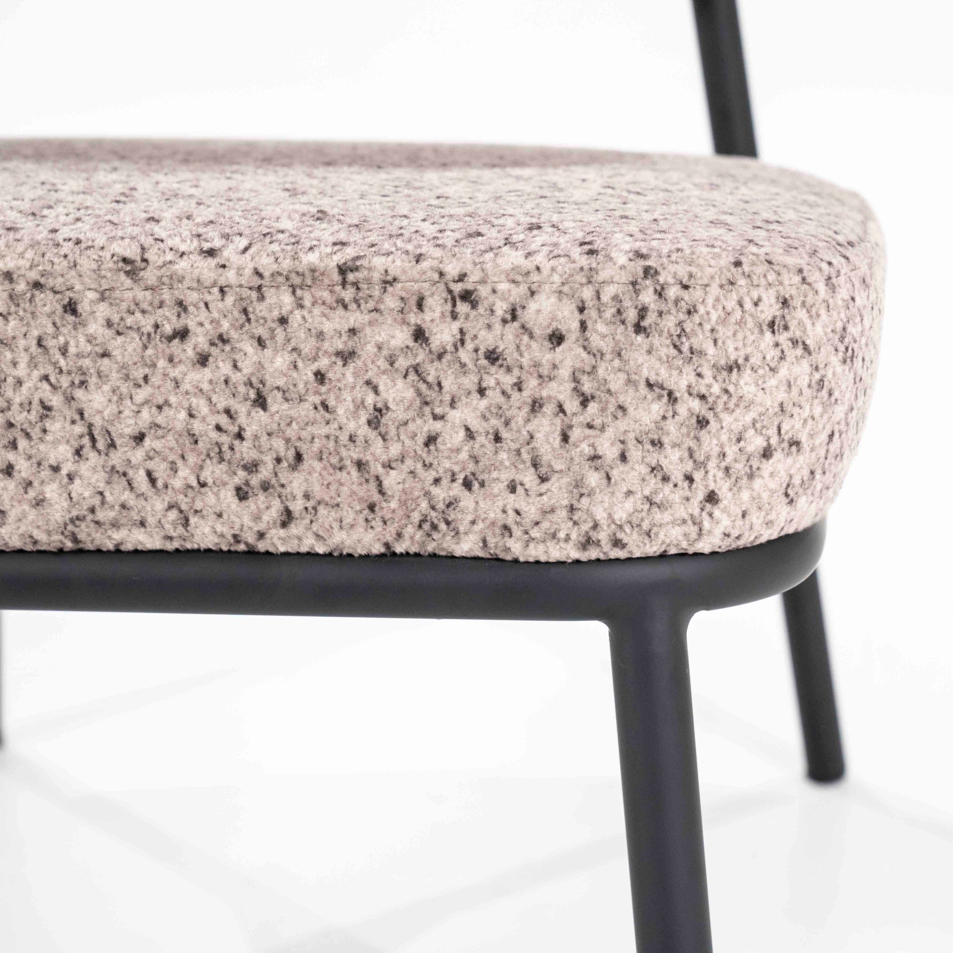 Lenestol i lyst melert stoff og svarte metallben