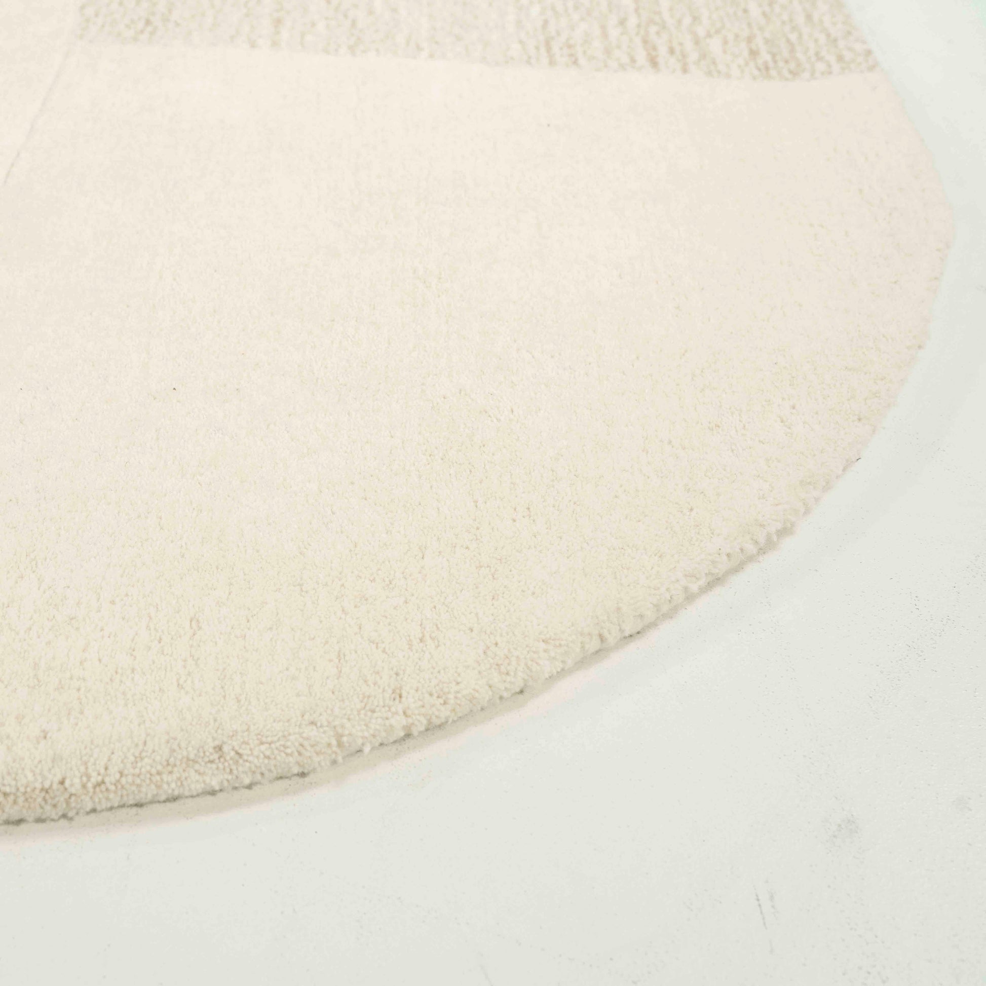 Kremfarget gulvteppe i ull. Rutete mønster på gulvteppe.