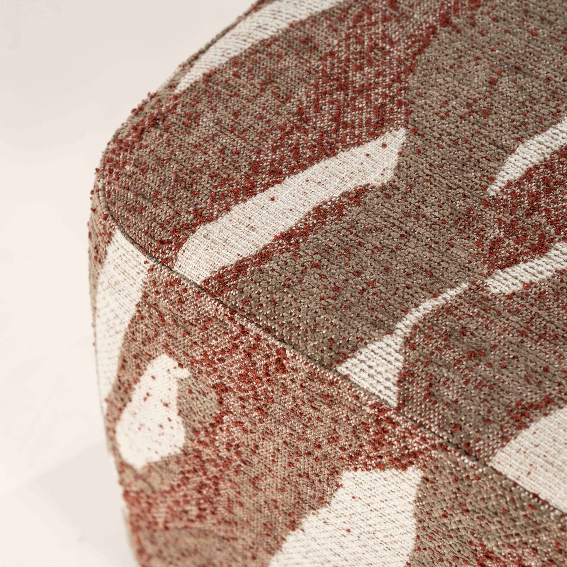 Firkantet puff i organisk mønster. Lyse felt blandet med terrakottarøde felt.