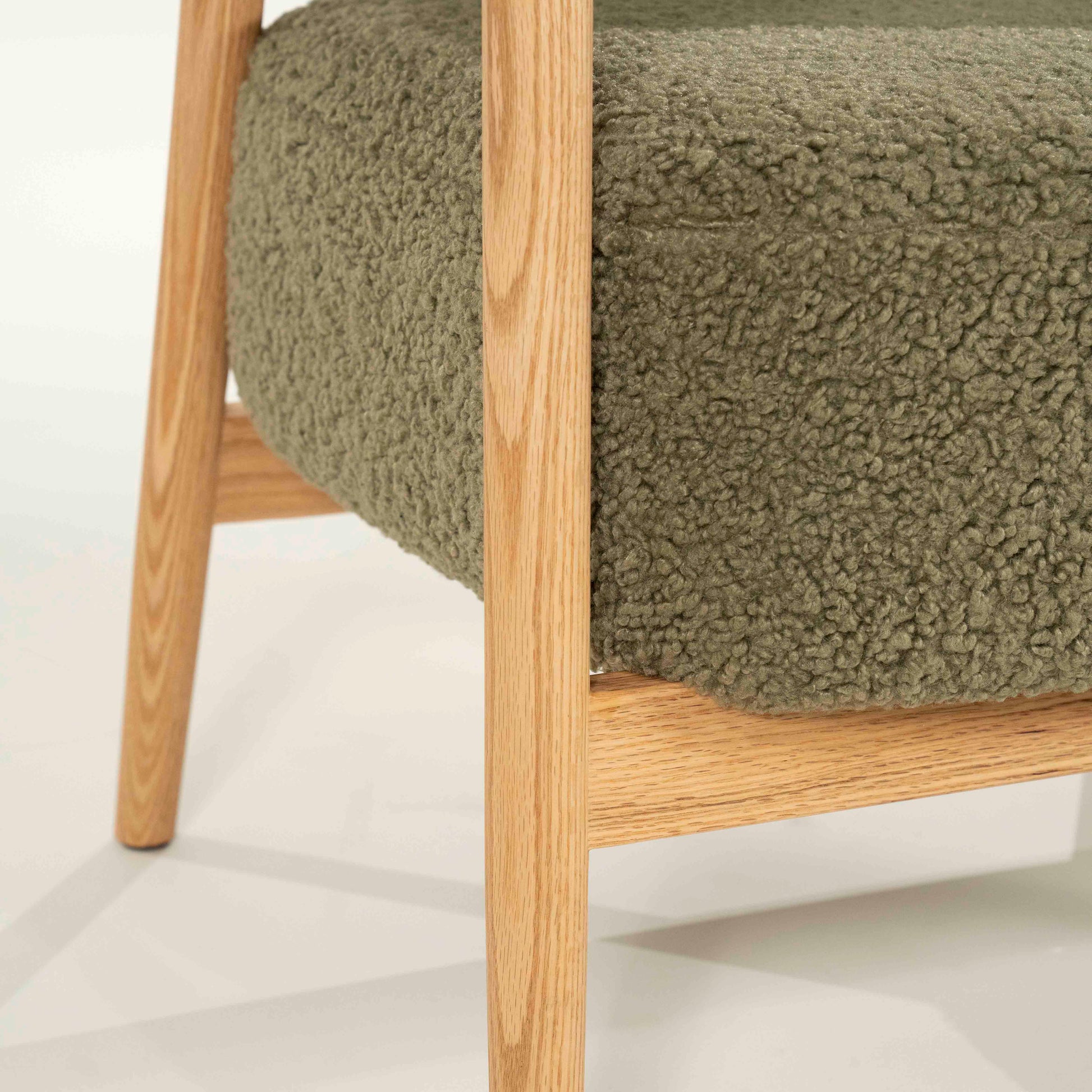 Lenestol med grønt teddystoff og lyse eikeben