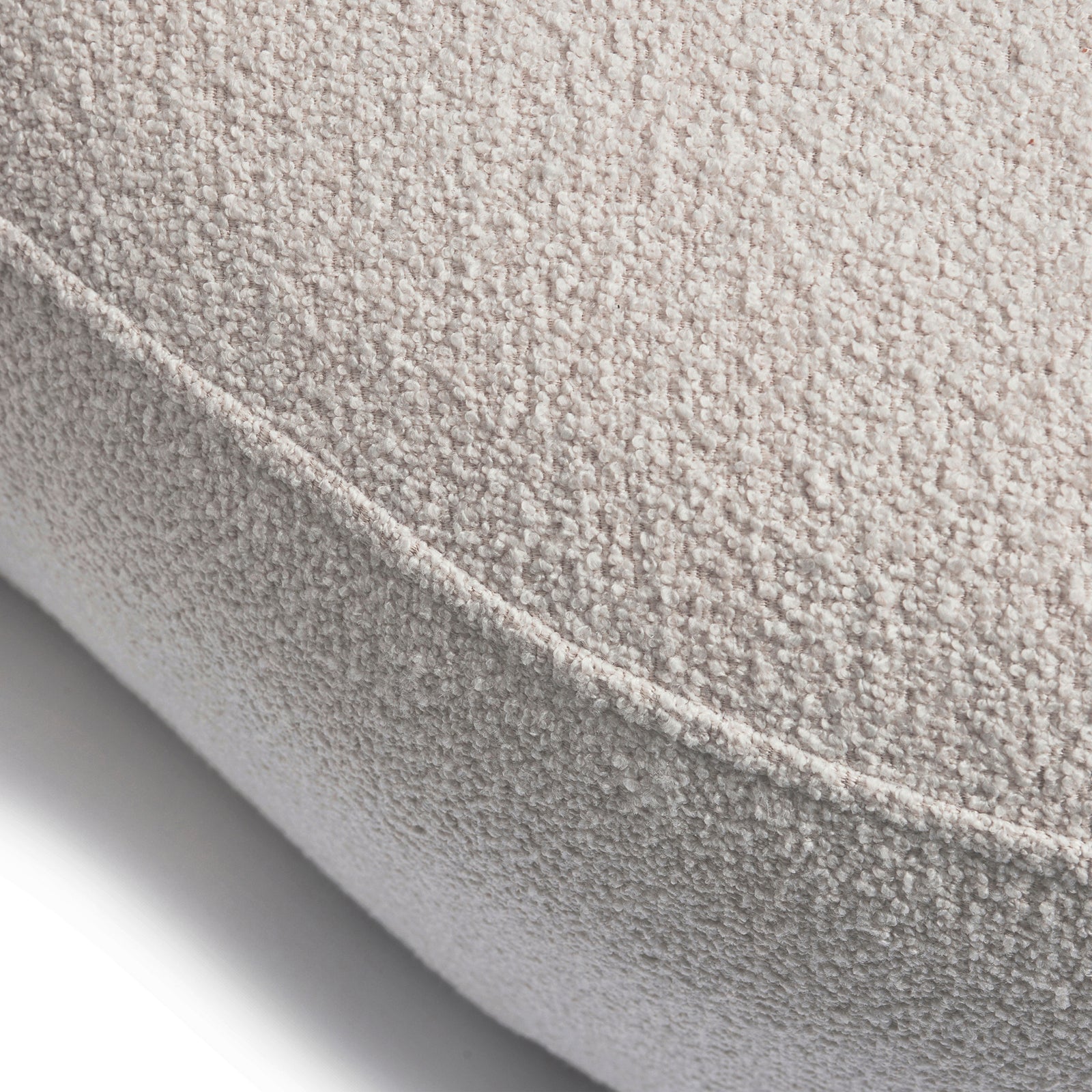 Nærbilde: Hvit buet sofa 3-seter i myke, organiske former. Bouclé-stoff