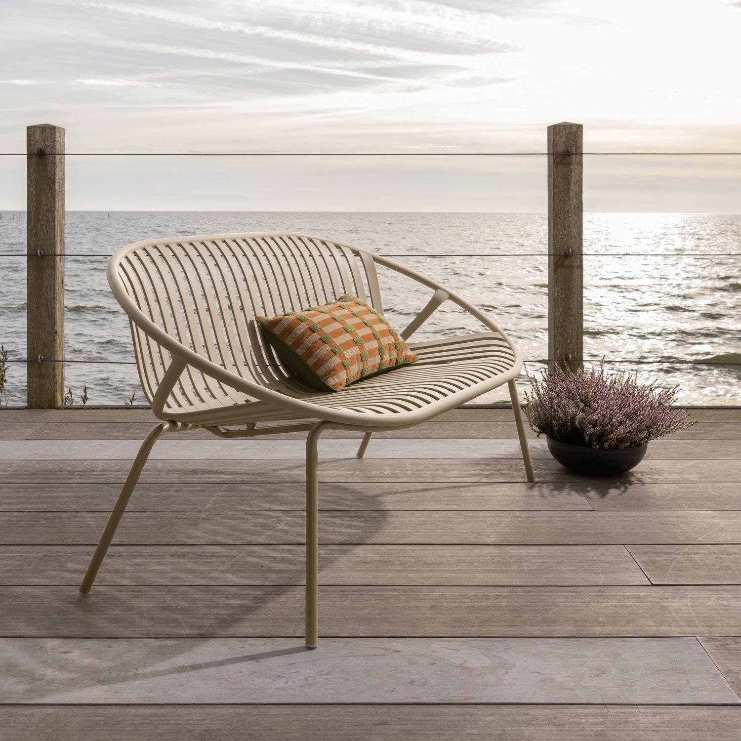 Stilren 2-seters hagebenk  med runde former og spiler i ryggen. 