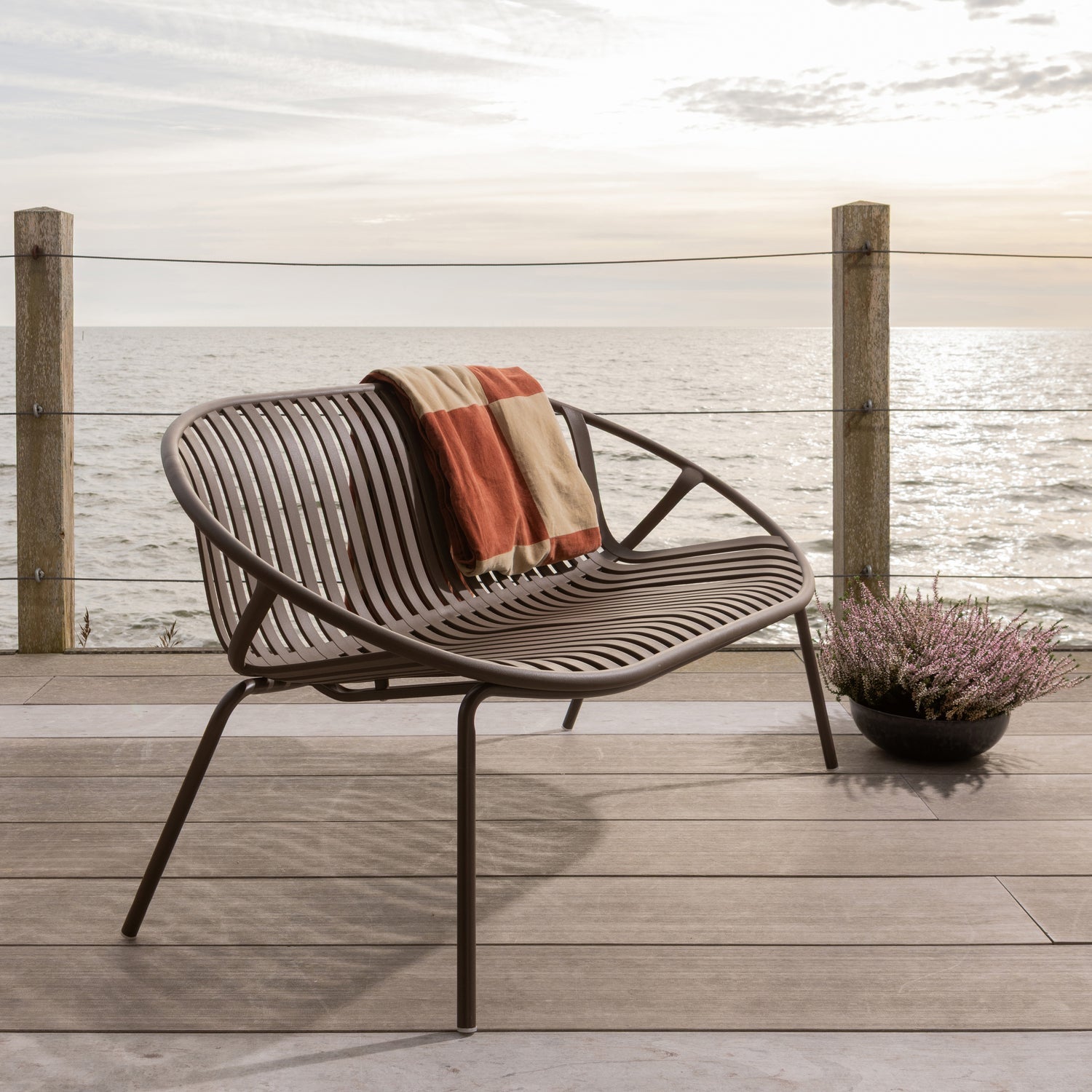 Stilren 2-seters hagebenk  med runde former og spiler i ryggen. 