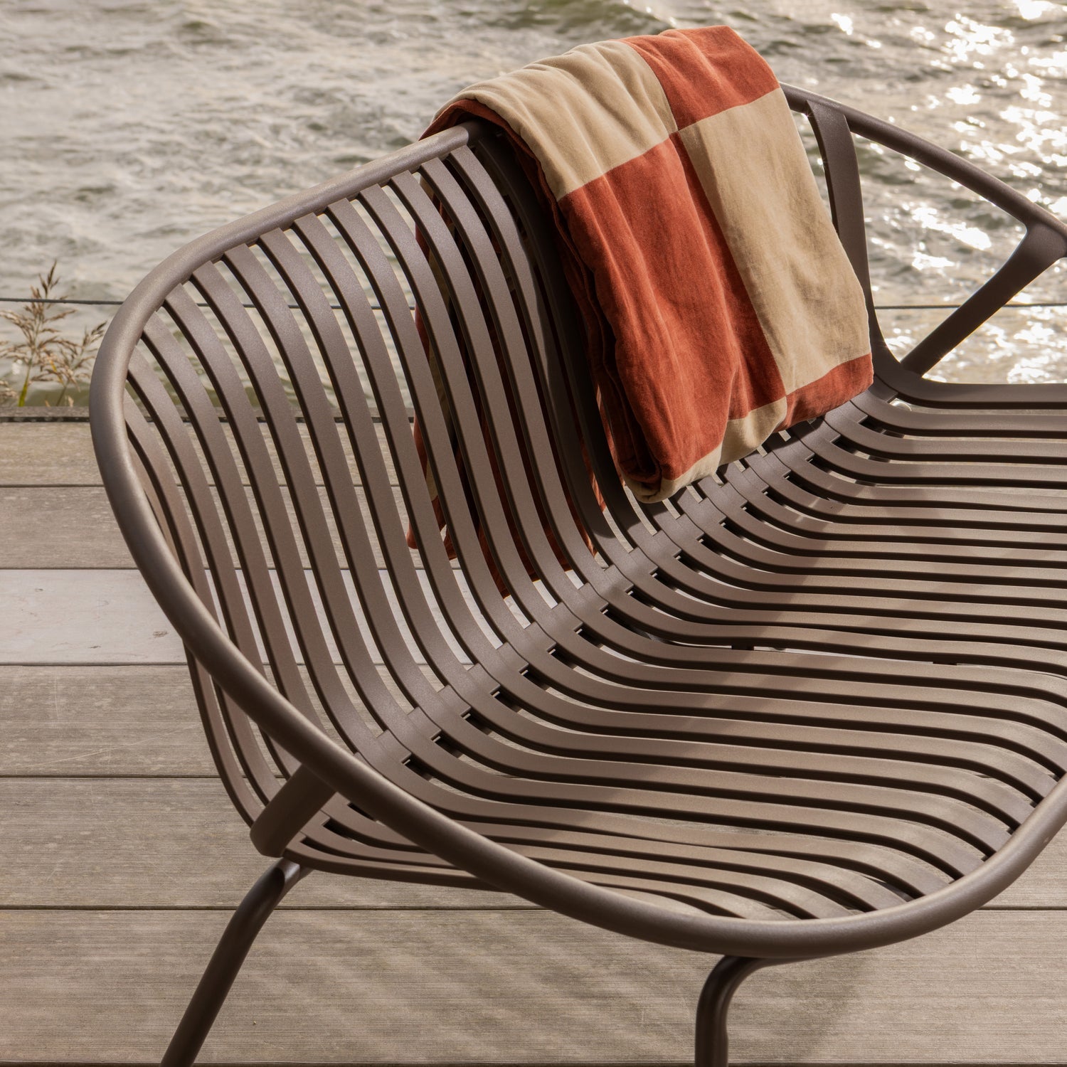 Stilren 2-seters hagebenk  med runde former og spiler i ryggen. 