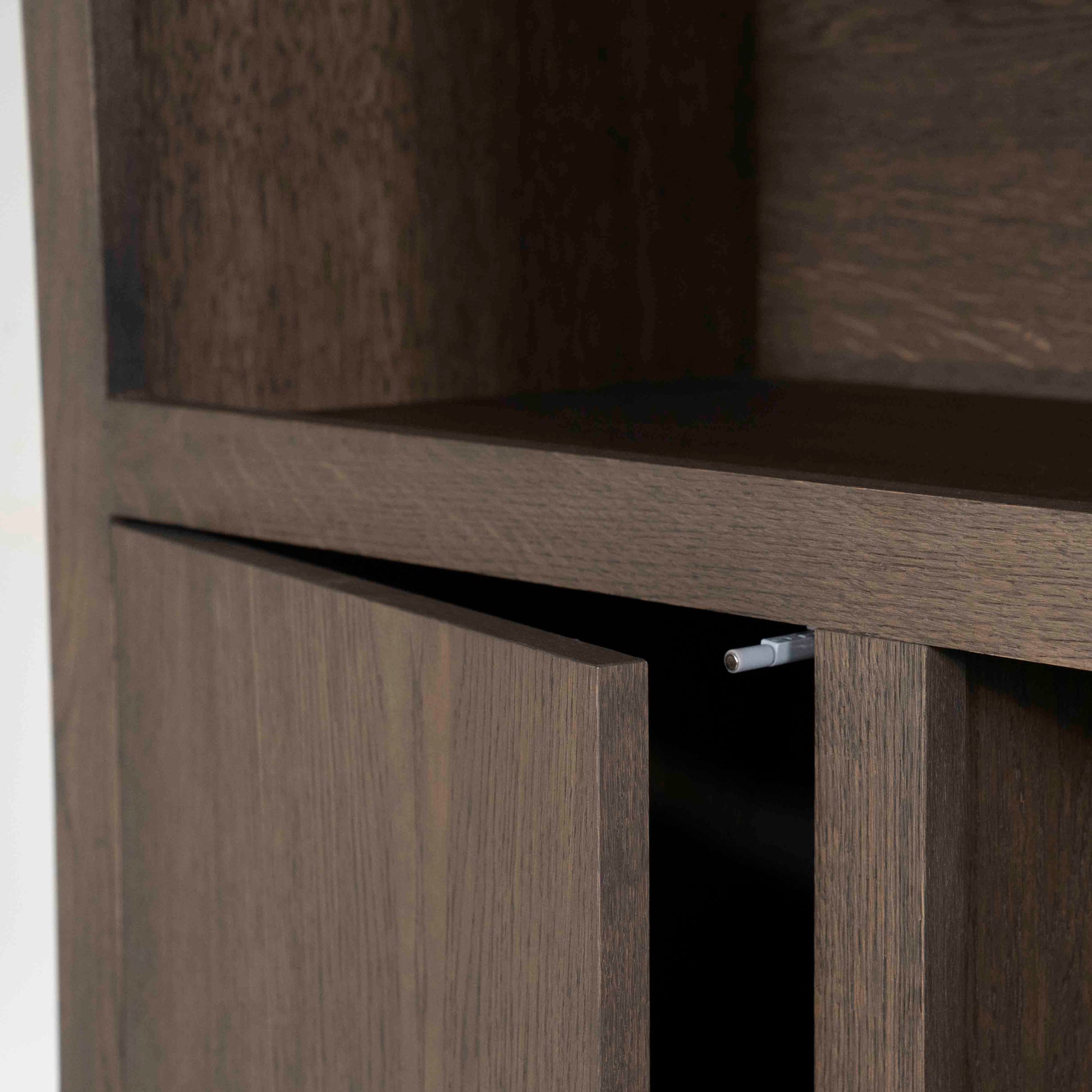 Helsinki bokhylle med skuffer og dører, mørk eik. Detaljebilde av dør med trykkåpning.