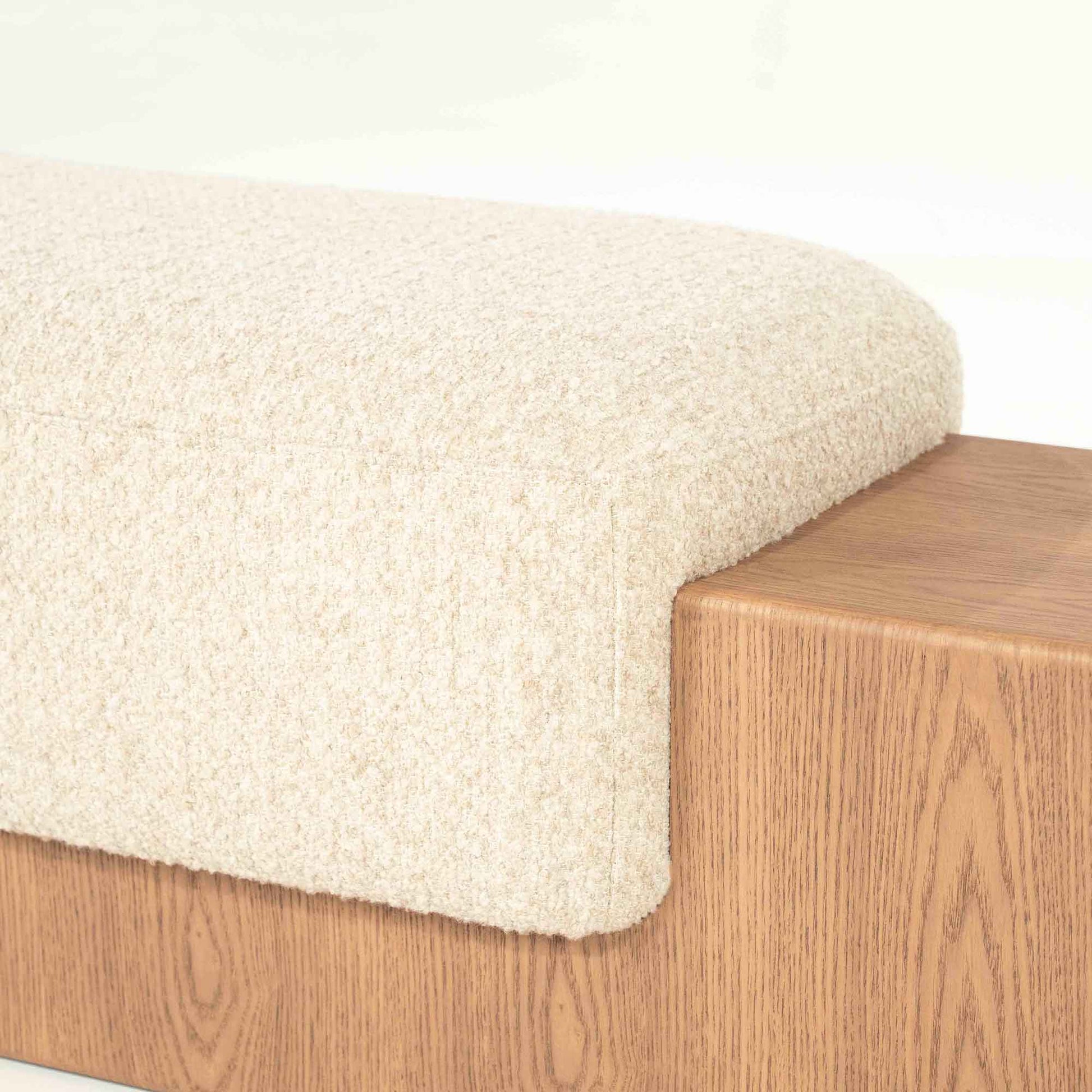 Sittebenk med solid tresokkel og sittepute i lys beige stoff.