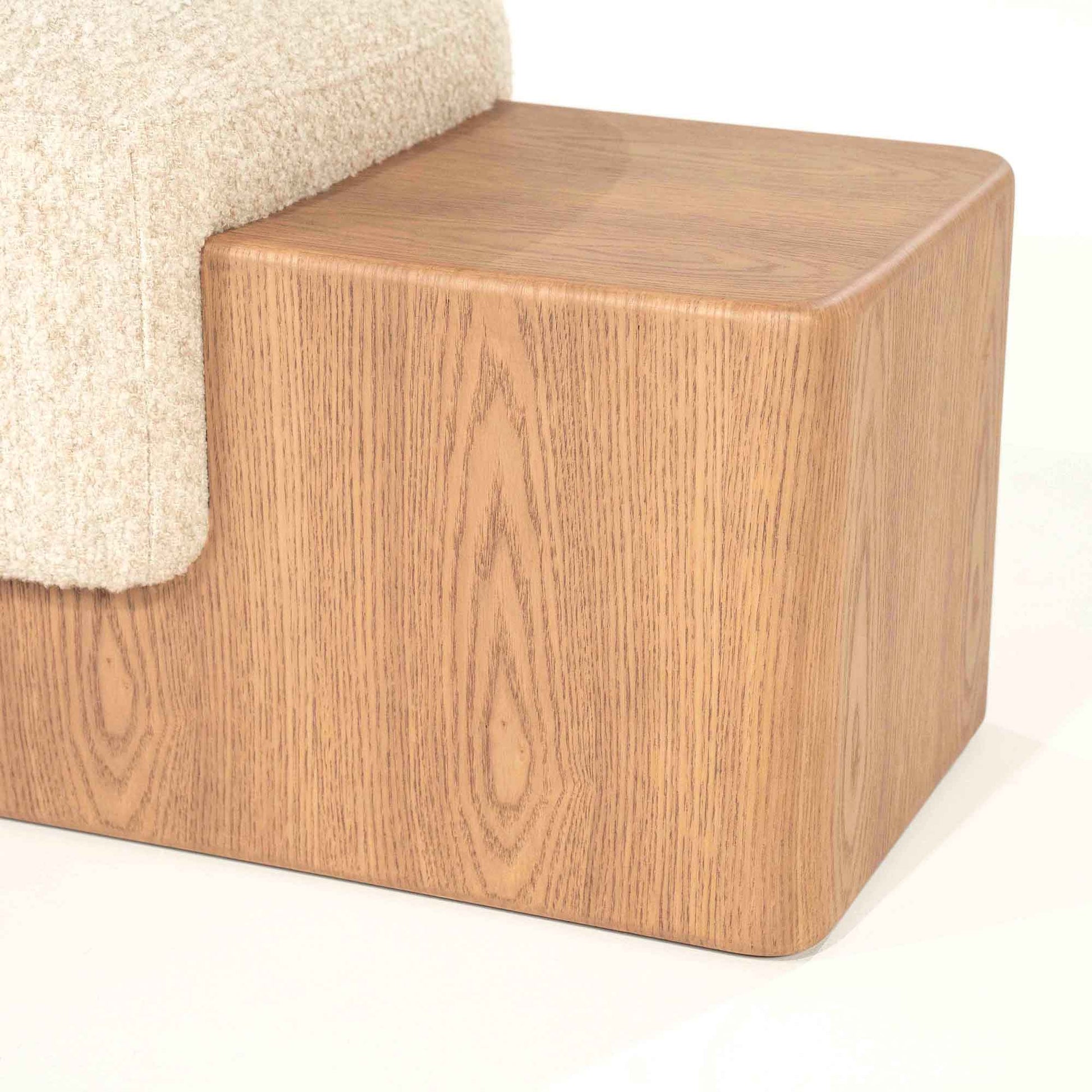 Sittebenk med solid tresokkel og sittepute i lys beige stoff.