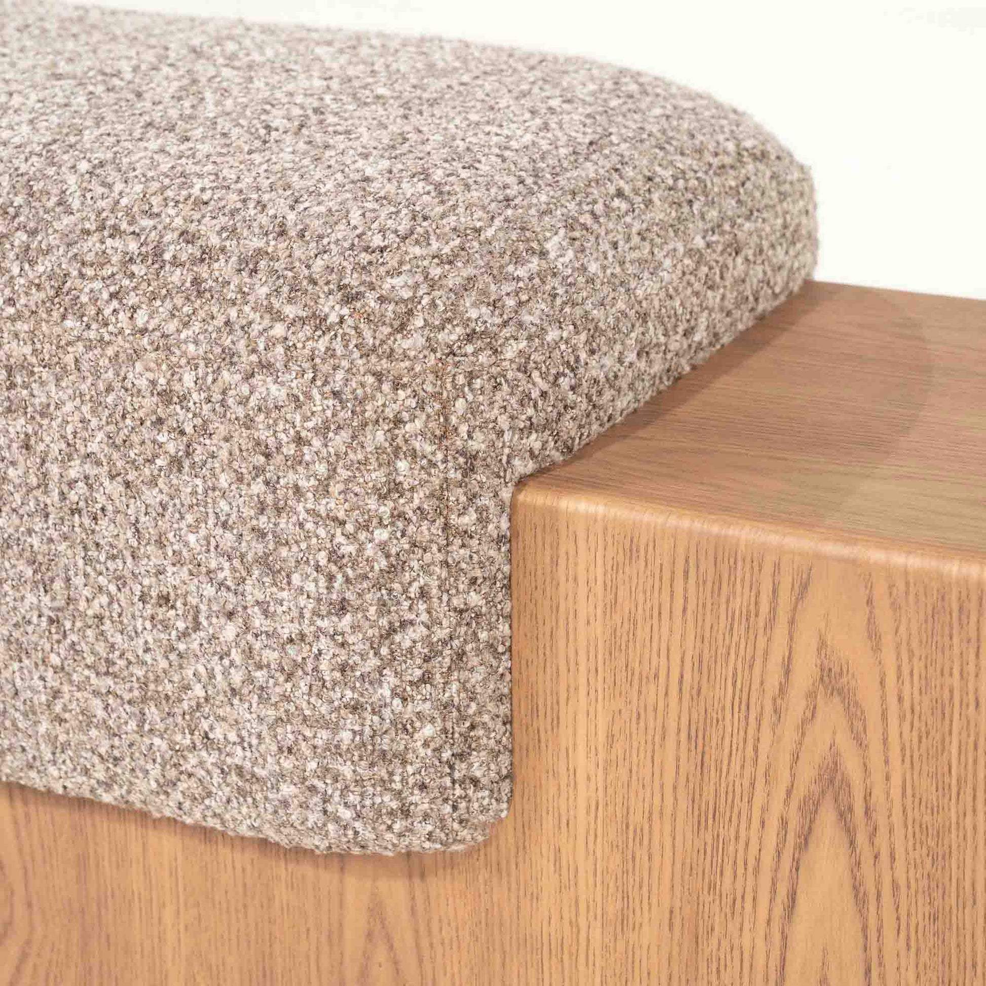 Sittebenk med solid tresokkel og sittepute i beige stoff.