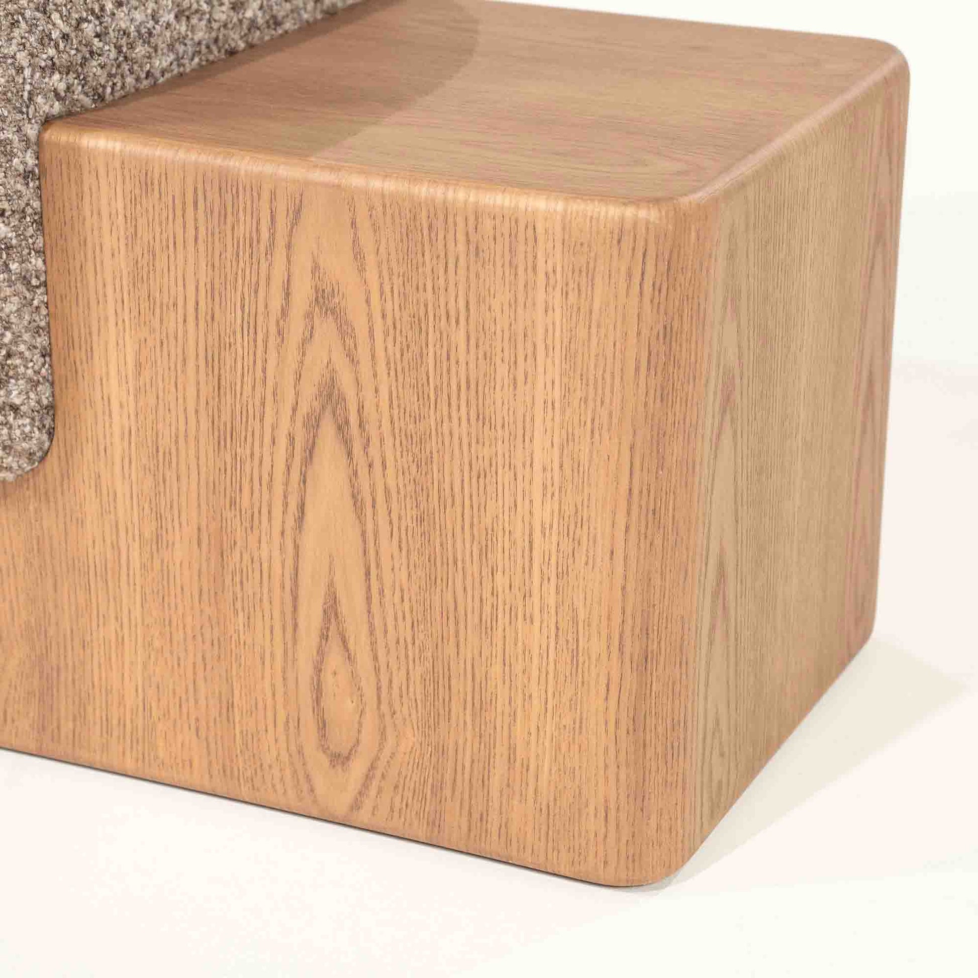 Sittebenk med solid tresokkel og sittepute i beige stoff.