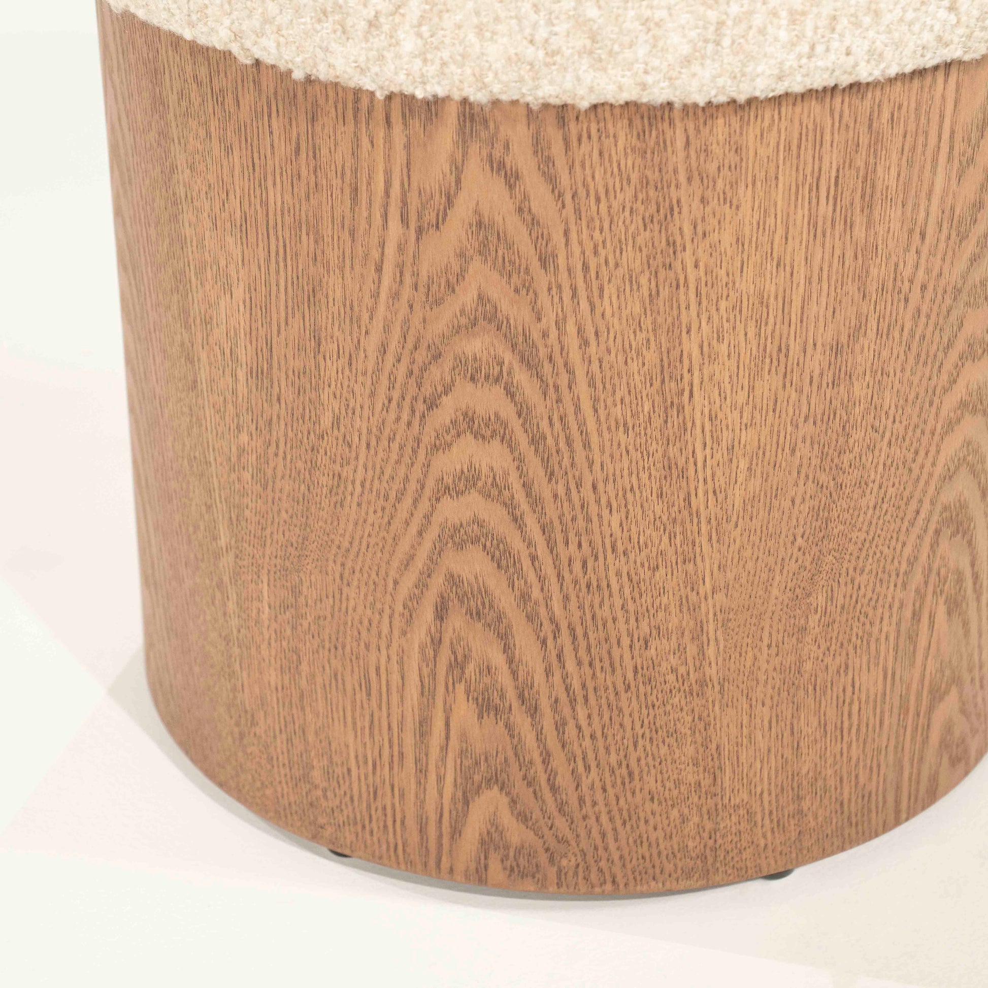 Puff med  lys beige pute og høy, solid sokkel i eik.