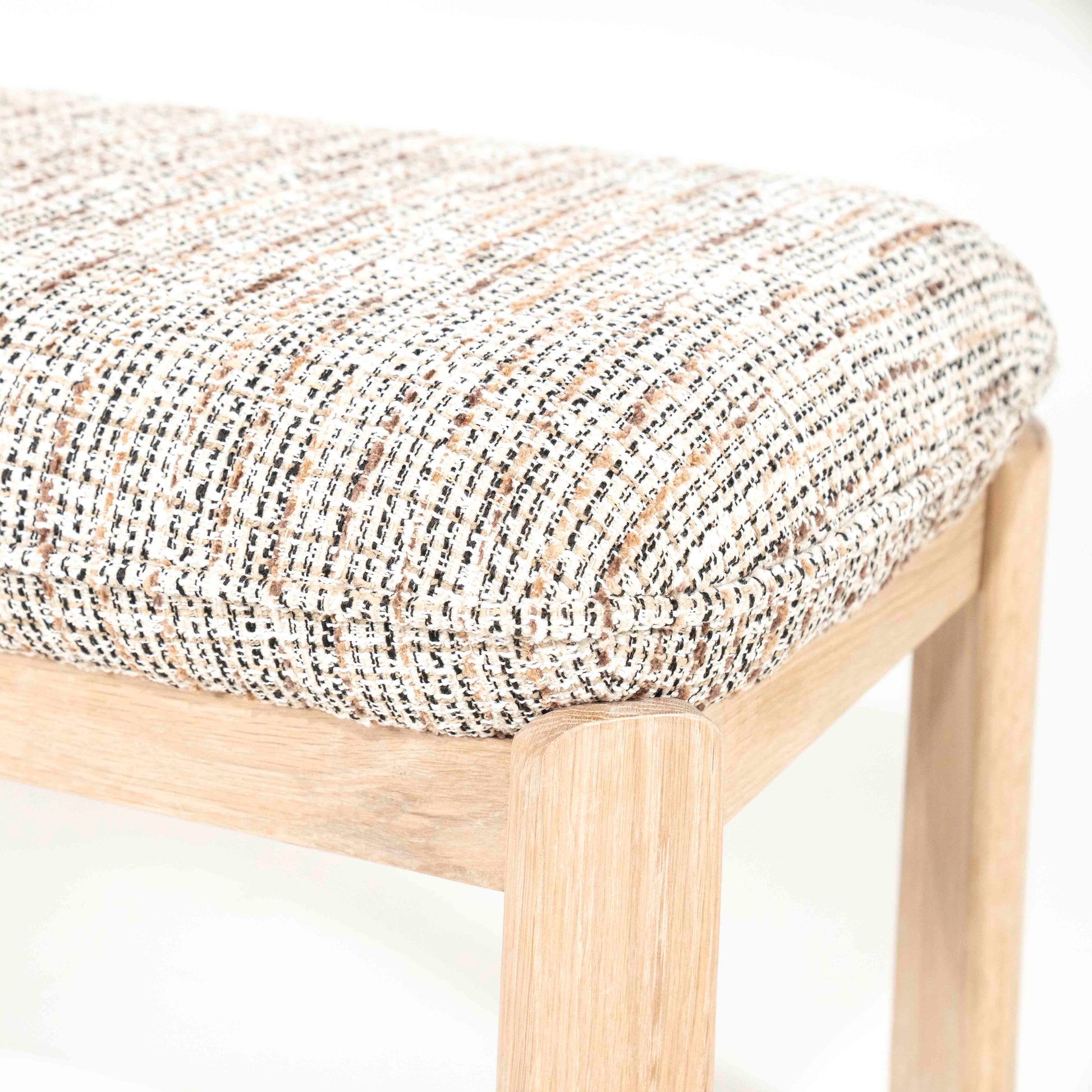 Benk i eik med beige- og brunmelert pute.