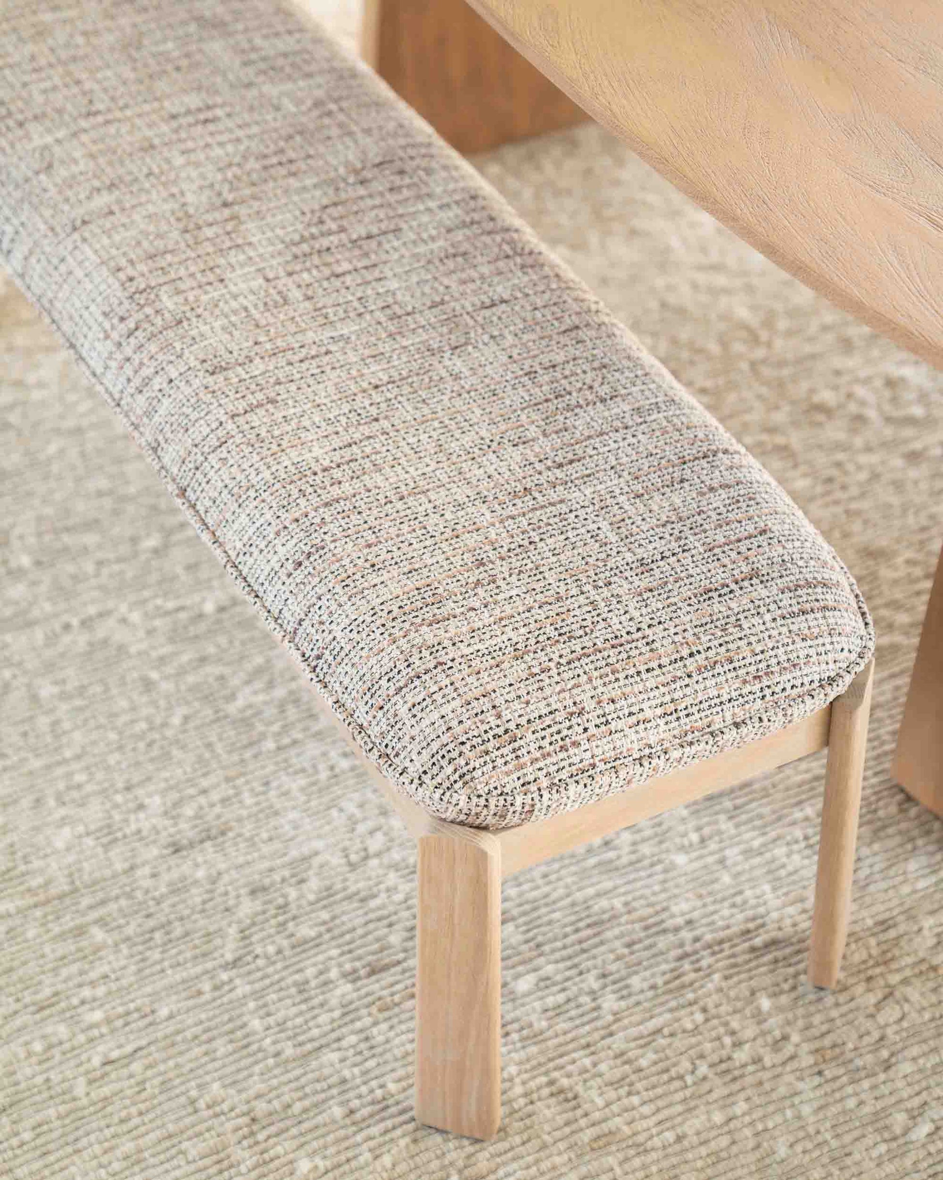 Spisebenk i eik med beige- og brunmelert pute.