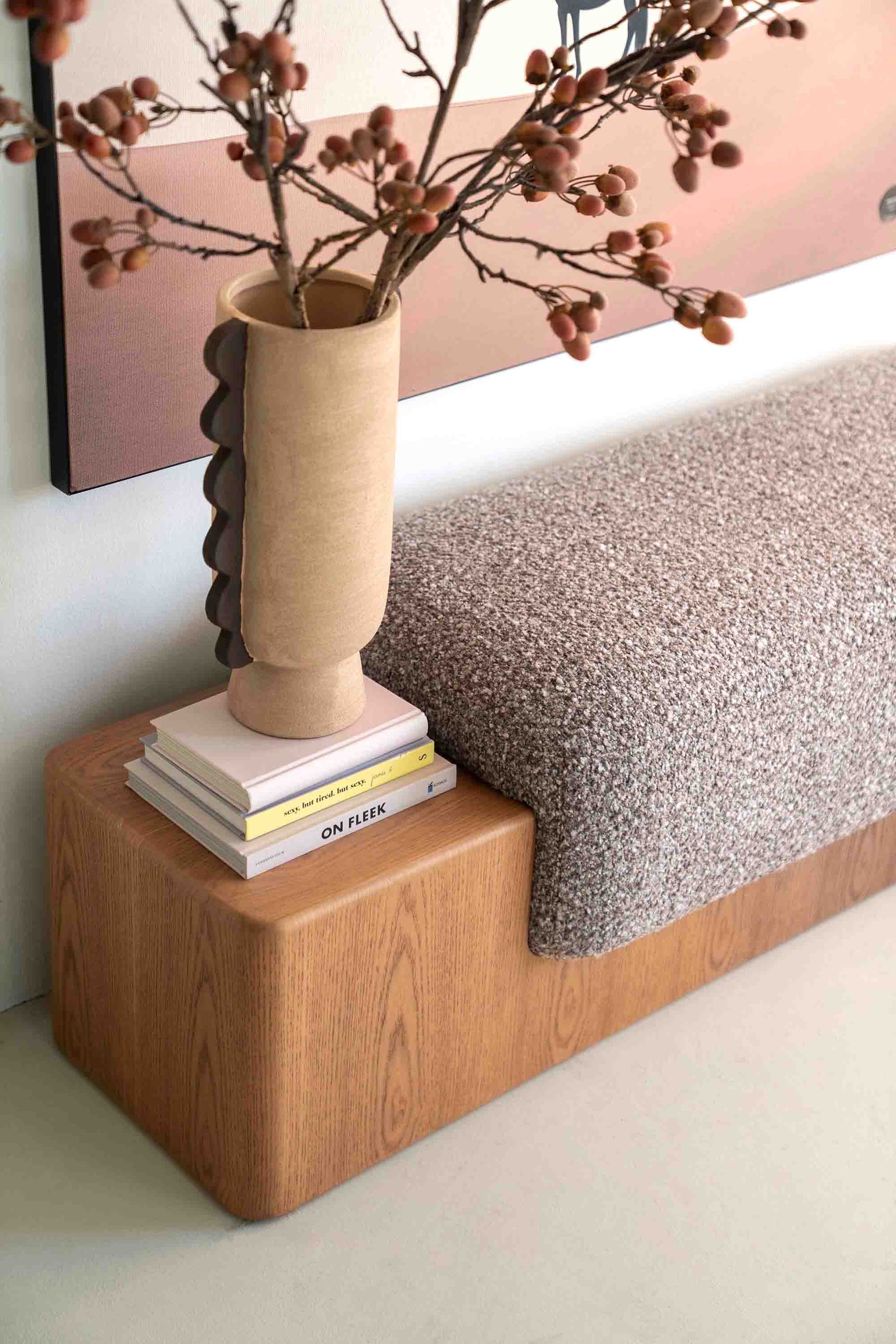 Sittebenk med solid tresokkel og sittepute i beige stoff.